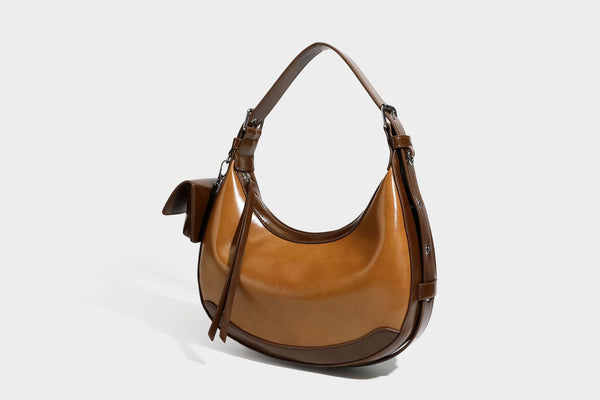 Glossy leather-look crescent hobo shoulder bag with dark contrast trim, silver-tone hardware, and attached mini flap pouch