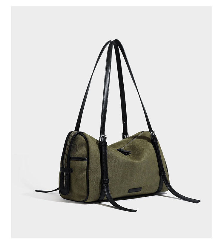Olivgrüne Schultertasche in Zylinderform aus Canvas mit Riemen in schwarzer Lederoptik, Reißverschluss oben und silberfarbenen Beschlägen, Detailansicht