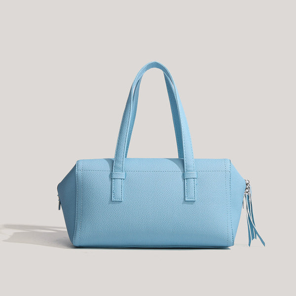 Light blue pebbled matte Boston tote bag with top handles, detachable shoulder strap, metal ring hardware, and matching mini