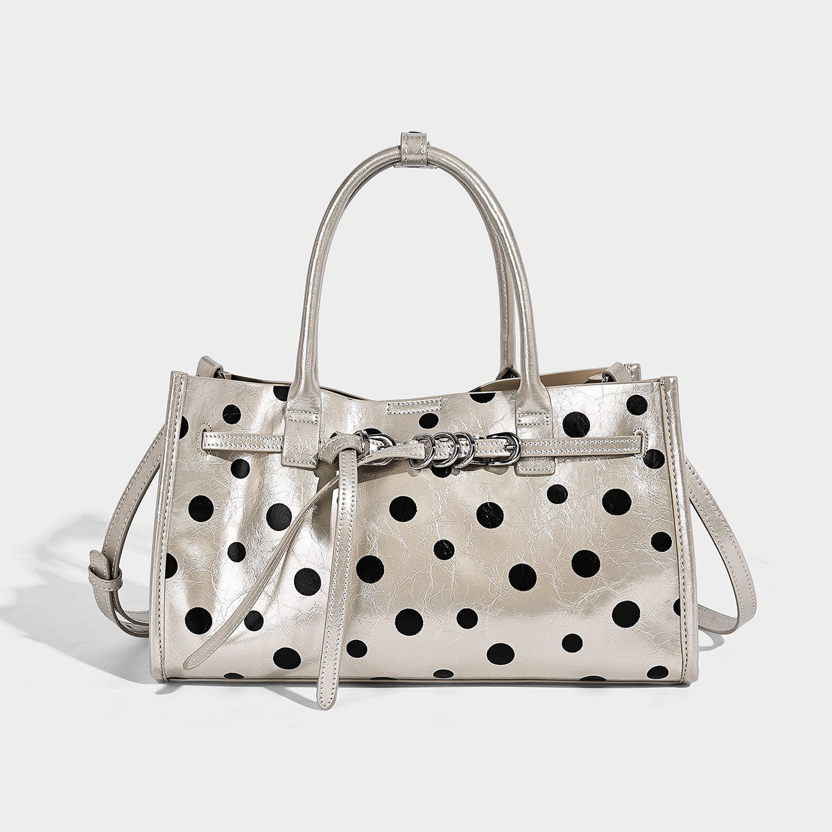 Structured glossy polka-dot tote bag with double top handles and front buckle hardware, detail view 7