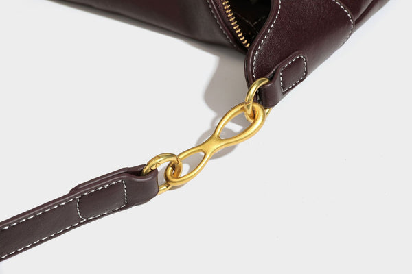 Lässige halbmondförmige Hobo-Schultertasche in Dunkelbraun mit goldfarbenem Ring und Kettenglied-Beschlägen sowie Reißverschluss oben, Detailansicht