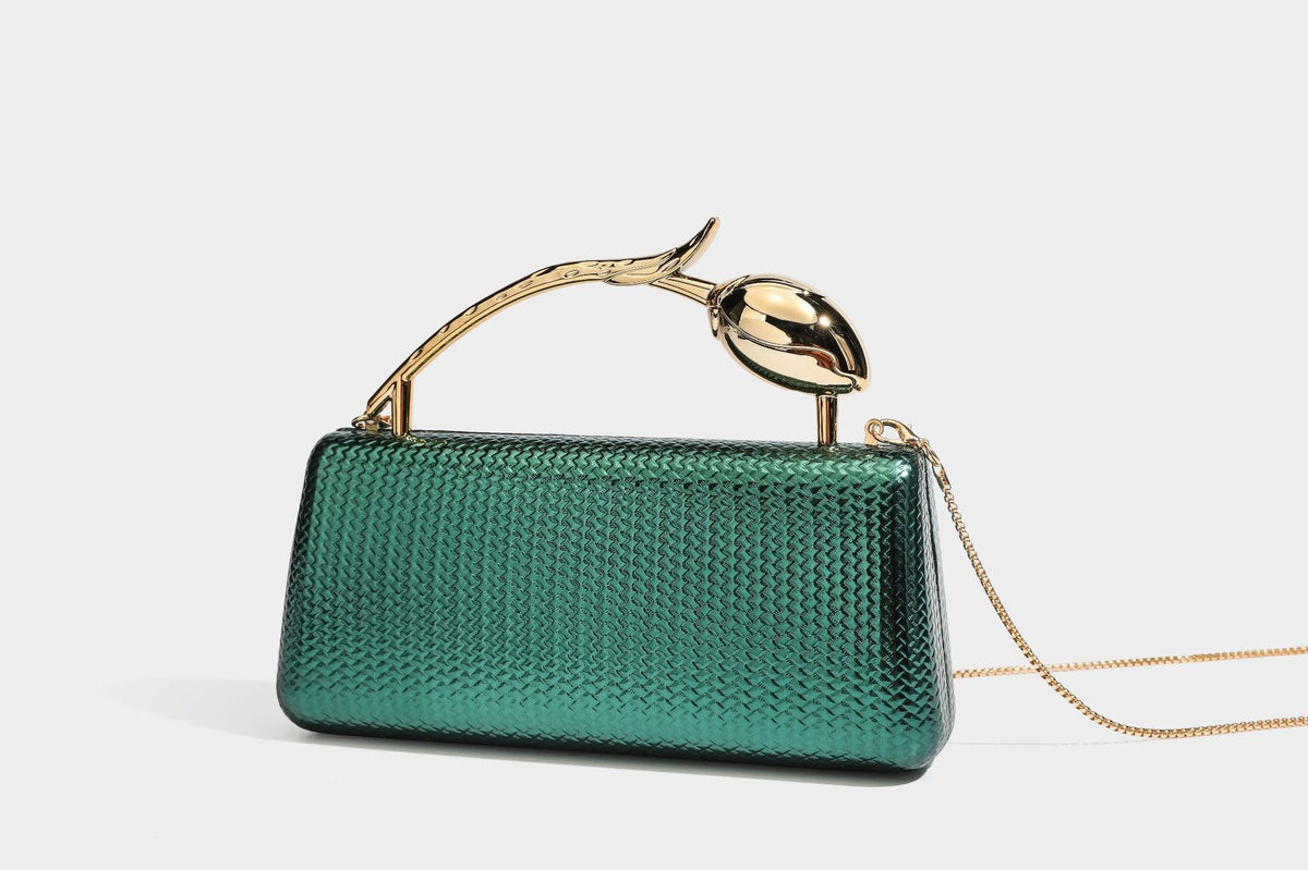 Structured rectangular metallic woven clutch bag with sculptural gold-tone leaf top handle and detachable chain strap, detail