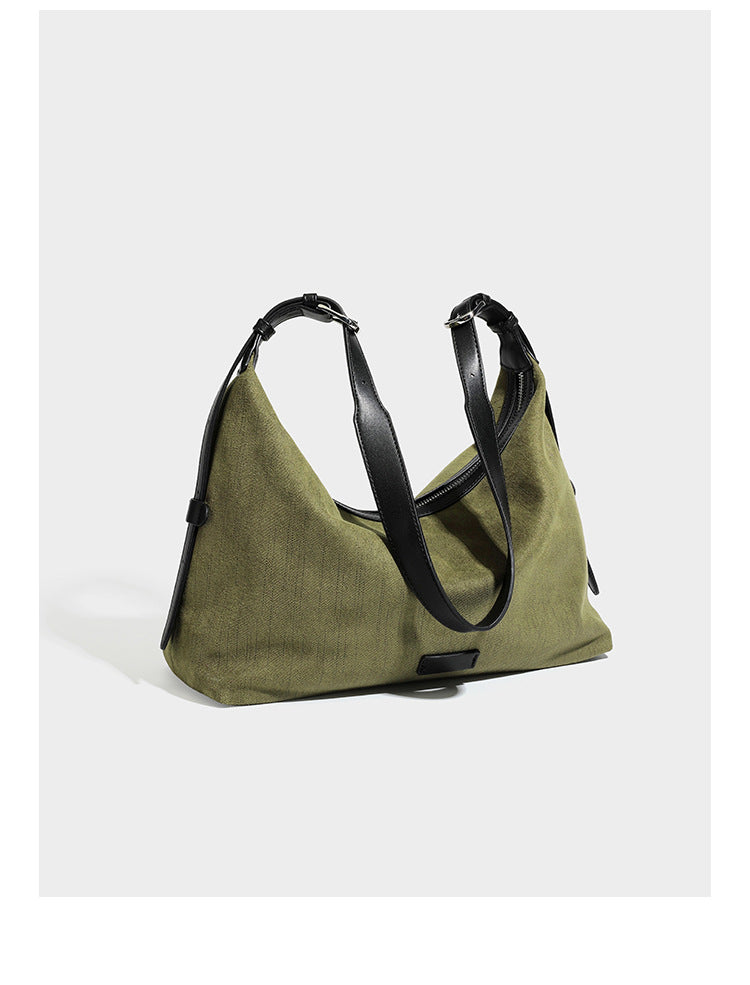 Slouchy olive green canvas hobo shoulder bag with black leather-look trim, zip-top closure, and adjustable strap, detail view