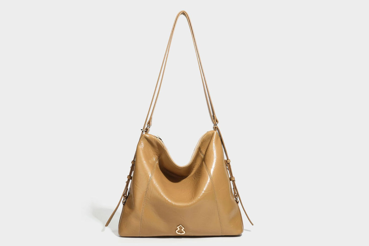 Große, lässig fallende Hobo-Schultertasche in glänzender, geknautschter Lederoptik mit goldfarbenen Beschlägen und langem, verstellbarem Riemen