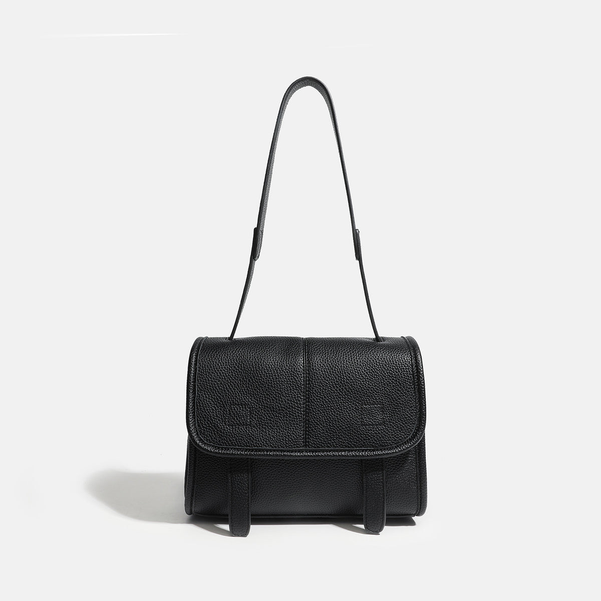 Compact structured flap satchel bag with pebbled texture, snap closure, front strap tabs, and long adjustable crossbody