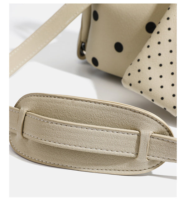 Strukturierte cremefarbene Henkeltasche mit Punktemuster, zwei Tragegriffen, silberfarbenen Beschlägen, abnehmbarem Schulterriemen und befestigtem