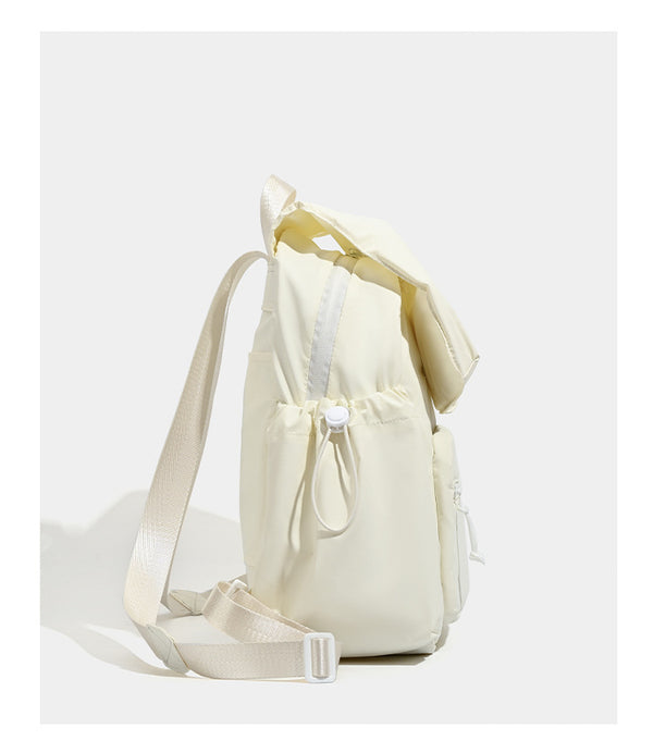 Soft matte nylon flap backpack with front zip pocket and side drawcord pockets, detail view 11
