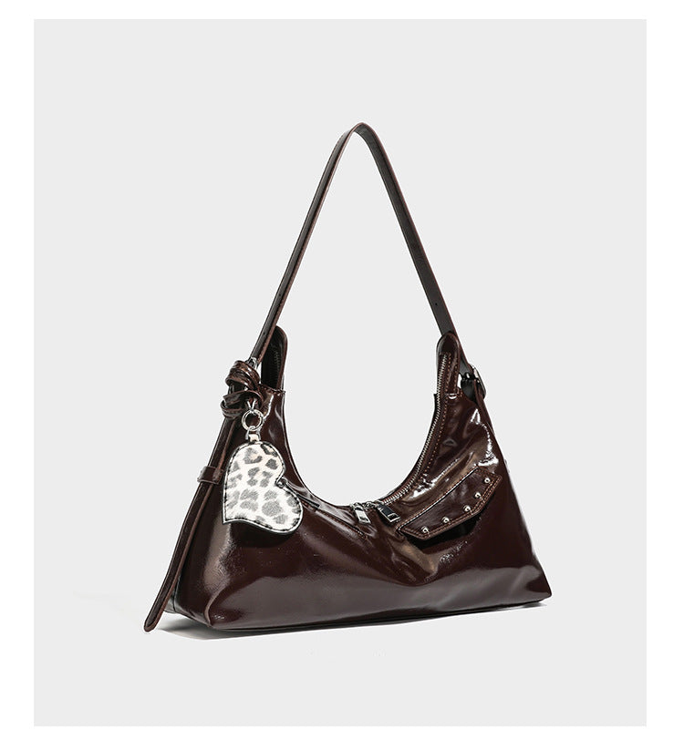 Glossy dark brown hobo shoulder bag with slim strap, front zip pocket, stud detail, and detachable leopard-print heart charm
