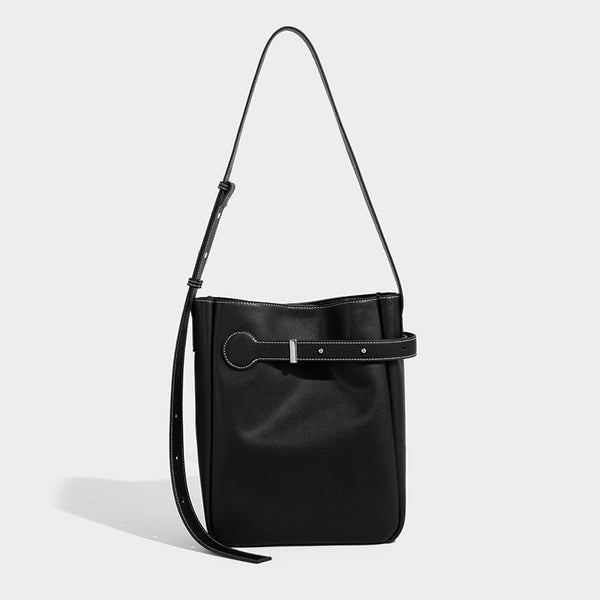 Structured dark brown leather-look bucket bag with white contrast stitching, front wraparound belt buckle strap, and long