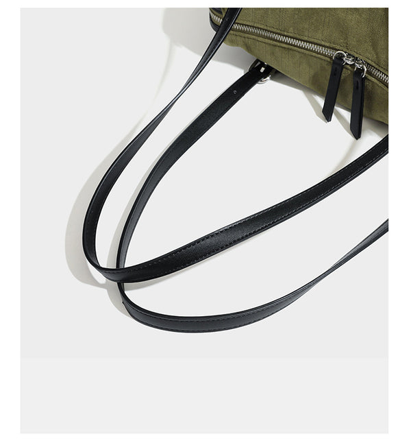 Olivgrüne Schultertasche in Zylinderform aus Canvas mit Riemen in schwarzer Lederoptik, Reißverschluss oben und silberfarbenen Beschlägen, Detailansicht