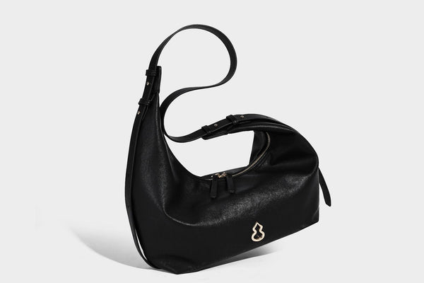 Lässig fallende, sichelförmige Hobo-Schultertasche in glatter dunkelbrauner Lederoptik mit Logo-Anhänger in Goldoptik und verstellbarem Schulterriemen