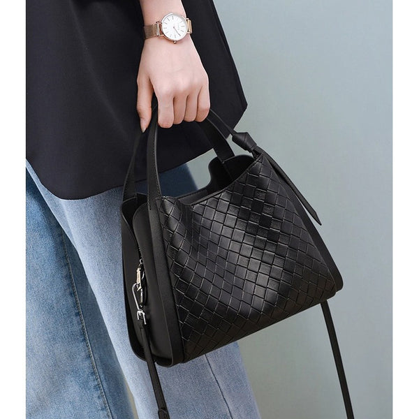 Black woven leather-look bucket tote bag with dual top handles and detachable shoulder strap, silver-tone hardware and zip