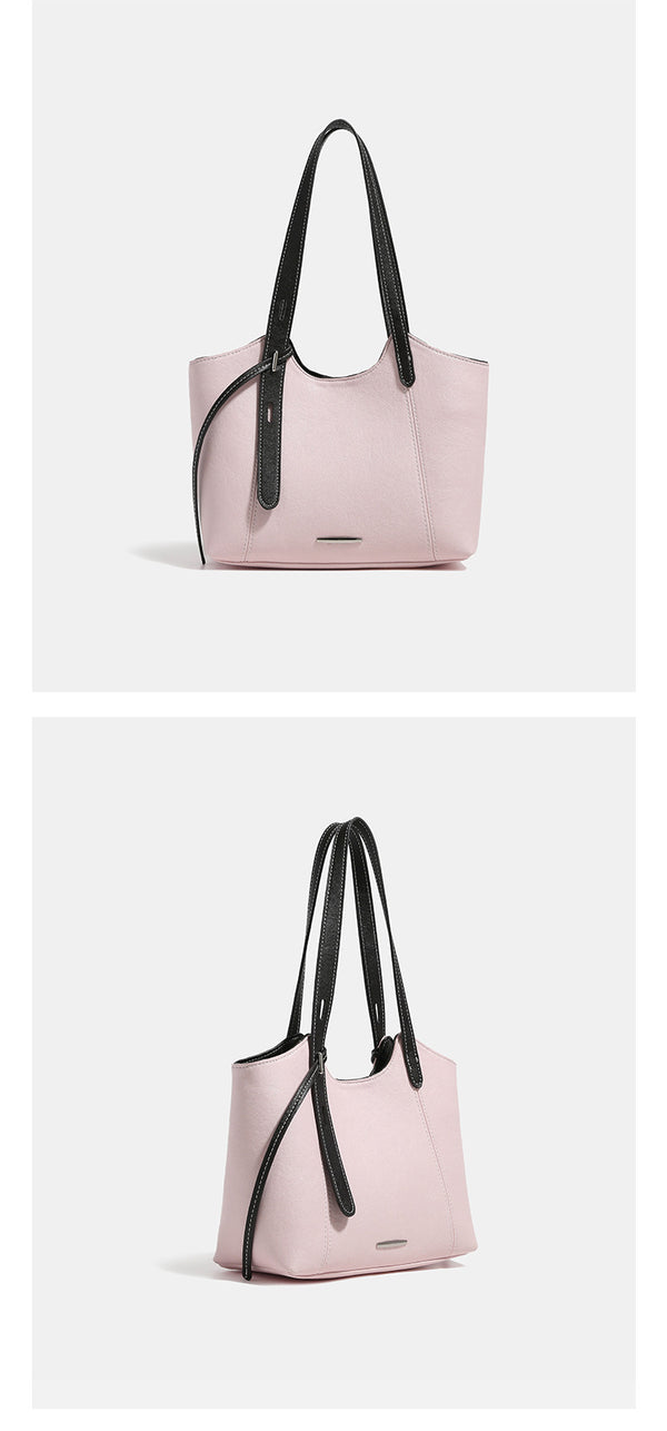 Structured trapezoidal tote bag with smooth leather-look finish, long black contrast shoulder straps, and dangling strap