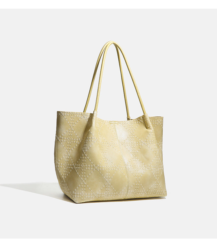 Large open-top tote bag with raised diamond-lattice stitching, long double shoulder handles, and gold-tone magnetic snap