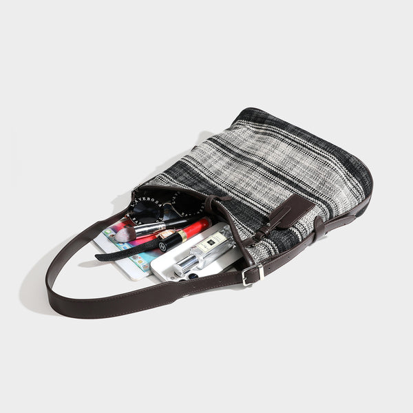 Schwarz-weiß karierte Hobo-Schultertasche aus gewebtem Material mit dunkelbrauner Einfassung in Lederoptik, Kordelzugverschluss und langem, verstellbarem