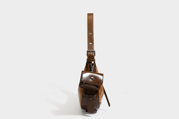 Glossy leather-look crescent hobo shoulder bag with dark contrast trim, silver-tone hardware, and attached mini flap pouch
