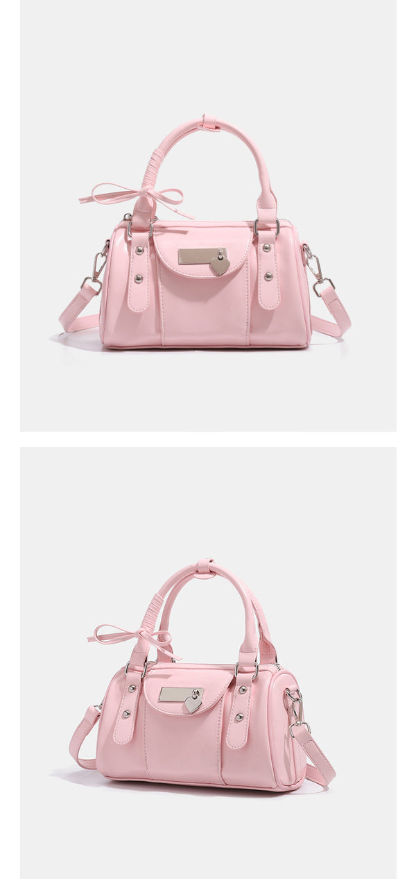 Kleine, formstabile Glanzledertasche mit zwei Henkeln, vorderer Klappentasche, herzförmigem Charm-Verschluss und silberfarbenem