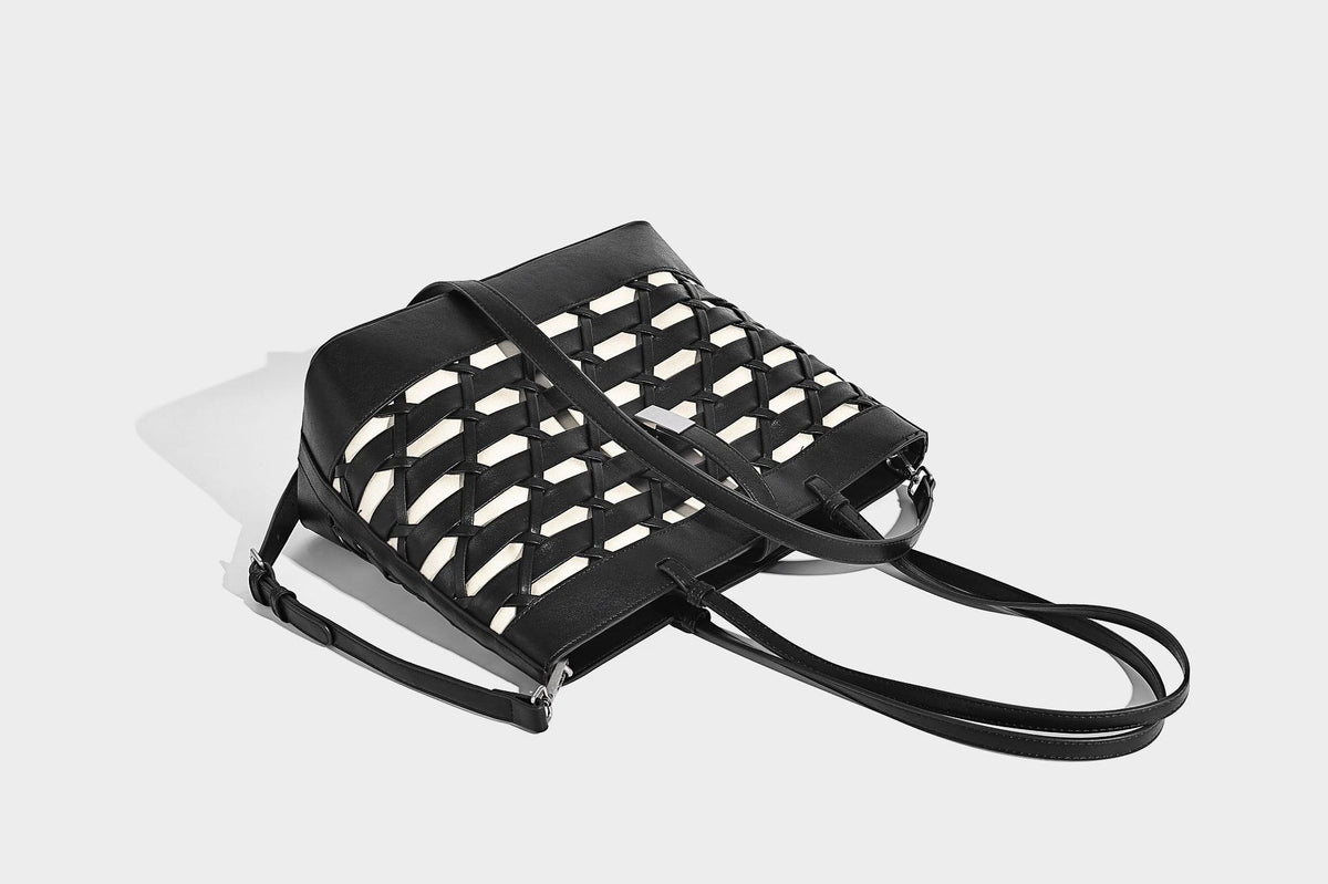 Structured woven lattice cutout tote bag with smooth leather-look trim, dual shoulder straps, and silver-tone hardware