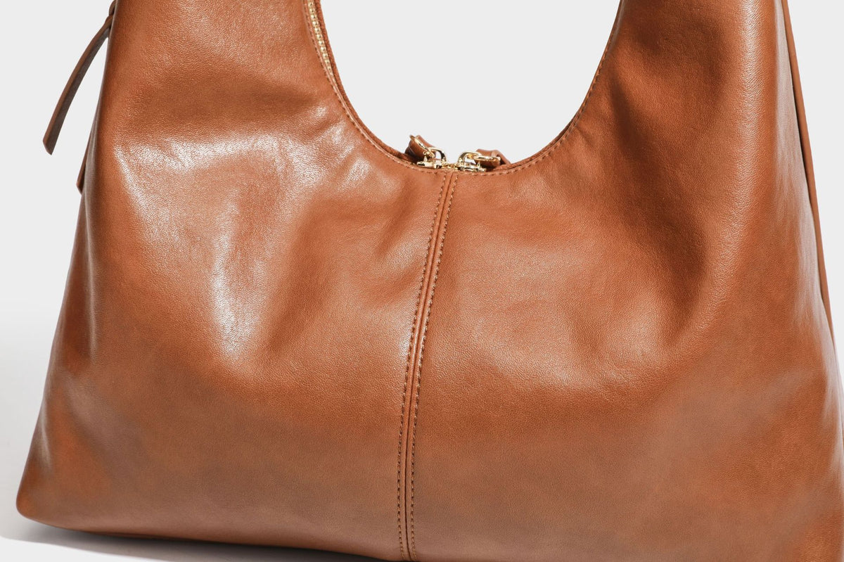 Lässig fallende Hobo-Schultertasche mit strukturierter Wildlederoptik, Reißverschluss oben, Quasten-Zippern und goldfarbenem, verstellbarem