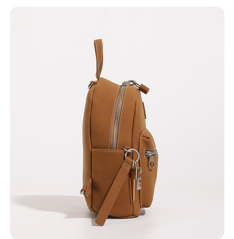 Mini-Rucksackhandtasche mit abgerundeter Form und genarbter Oberfläche, silberfarbenen Beschlägen, Reißverschlussfach vorne und verstellbaren Rucksackriemen