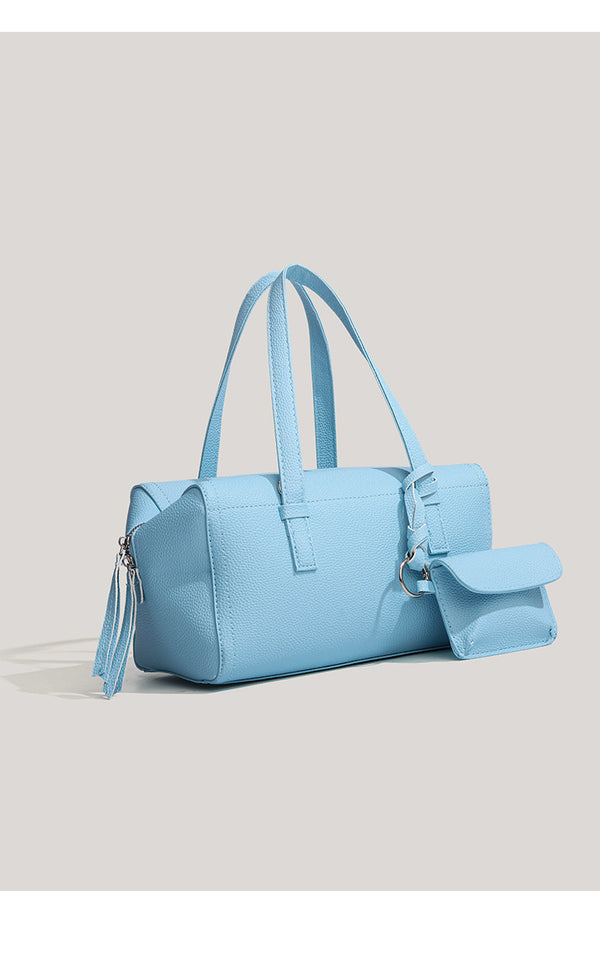 Light blue pebbled matte Boston tote bag with top handles, detachable shoulder strap, metal ring hardware, and matching mini