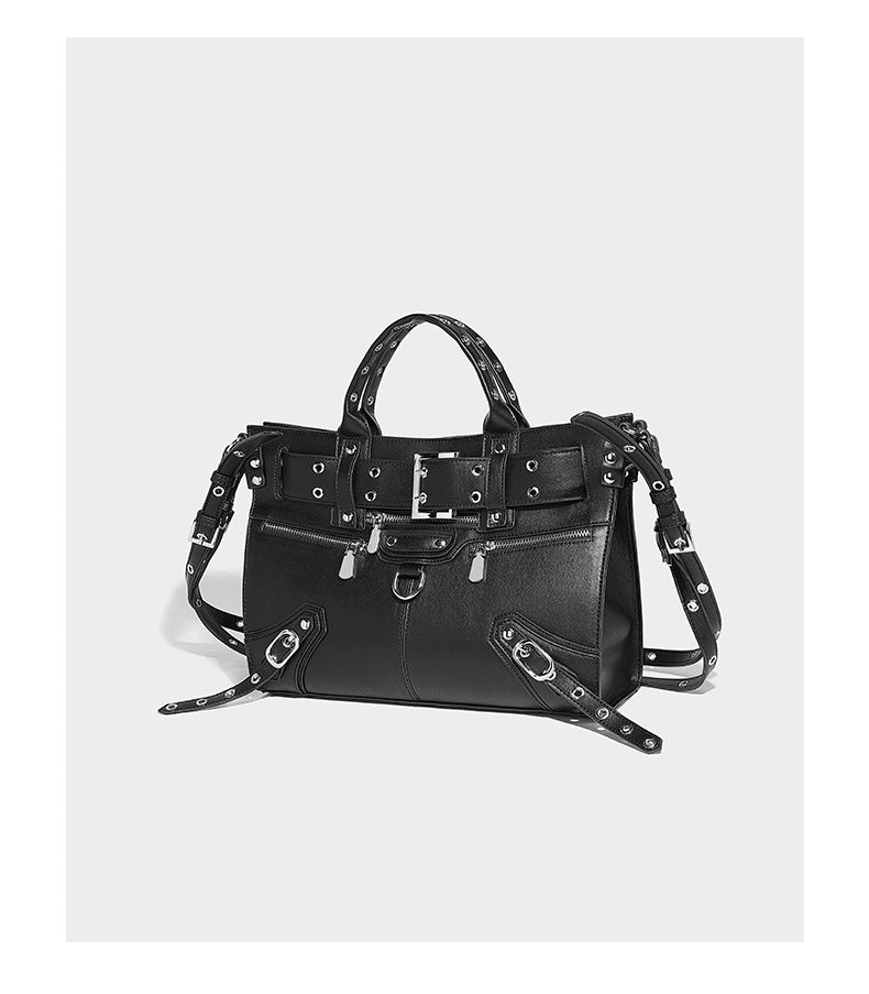 Black structured rectangular satchel bag with silver-tone rivets, large front buckle strap, zip pockets, dual top handles