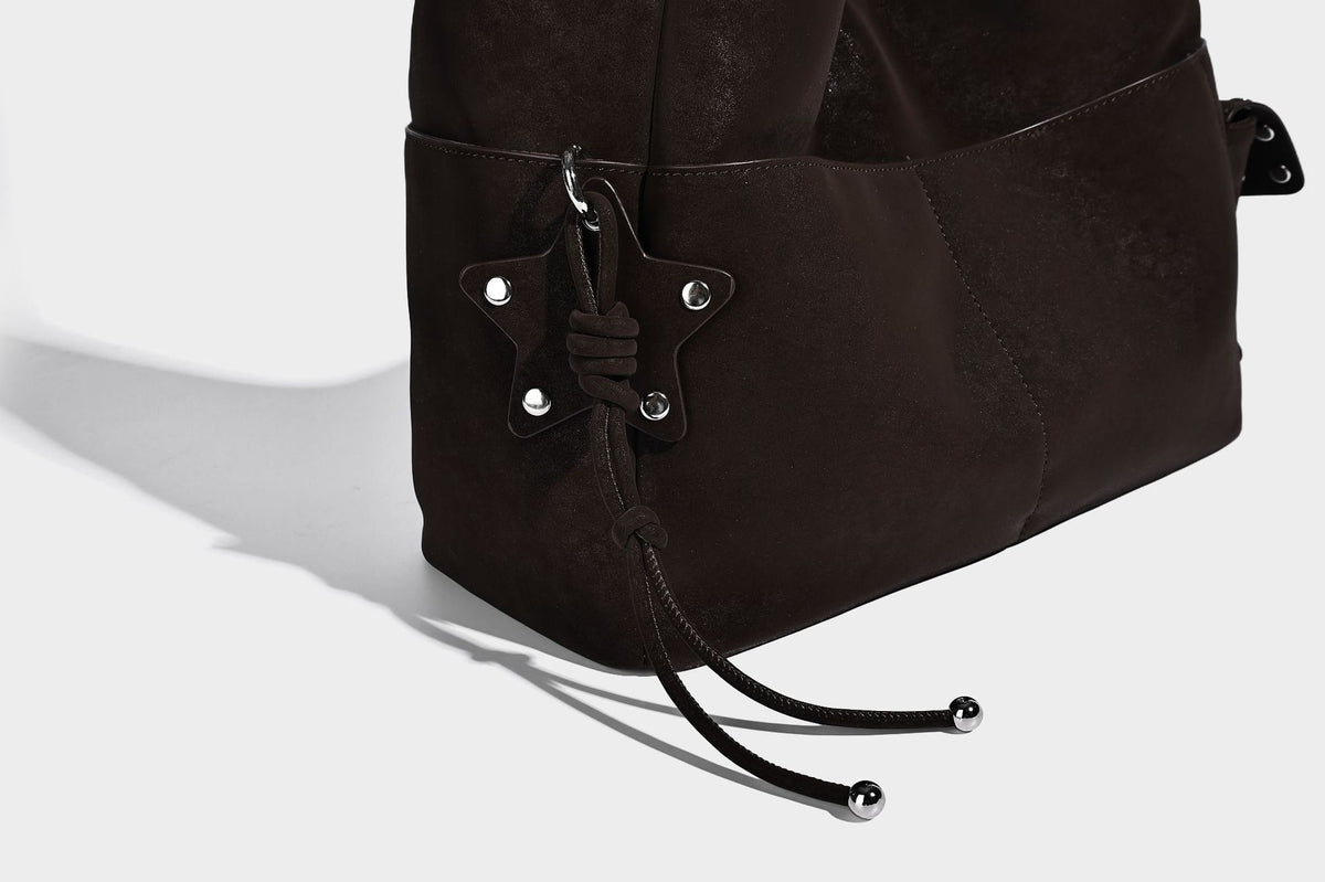 Lässige Hobo-Schultertasche in dunkelbrauner, matter Wildlederoptik mit silberfarbenem, nietenbesetztem Riemen und seitlichem Kordelzug