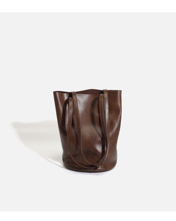Large black smooth leather-look bucket tote bag with long shoulder straps and open top, detail view 11