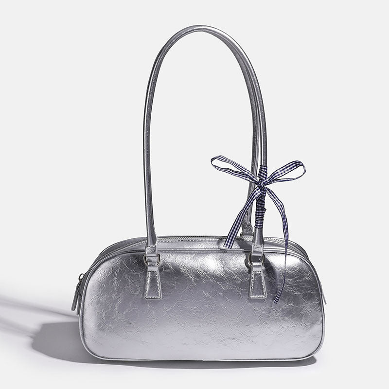 Rounded rectangular shoulder bag with glossy crinkled finish, dual long handles, top zip closure, and gingham ribbon bow