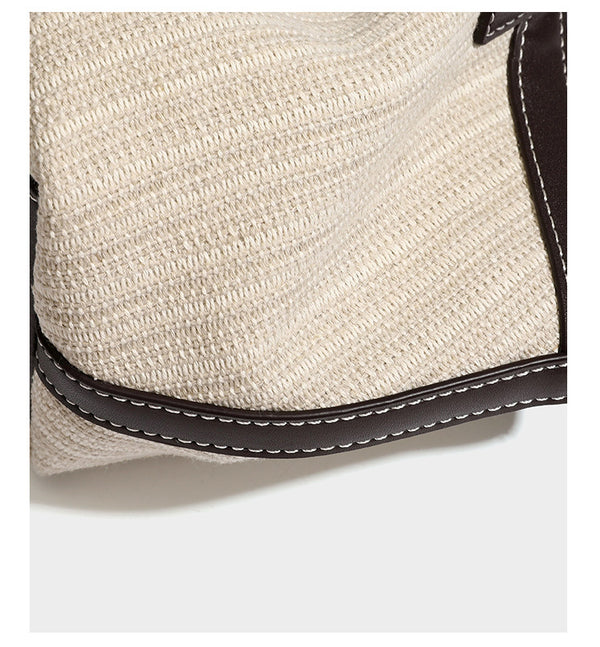 Cremefarbene geflochtene Tote-Bag mit dunkelbraunen Besätzen in Lederoptik, kontrastierenden weißen Nähten, zwei oberen Henkeln und abnehmbarem Schulter