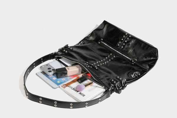 Black glossy leather-look slouchy shoulder bag with silver stud and eyelet hardware, top zip closure, front zip pocket, and