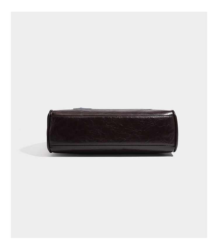 Structured glossy leather-look satchel bag with flap closure, gold-tone buckle accents, double top handles, detachable