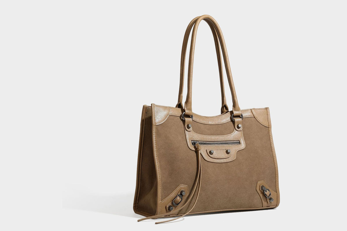 Large structured tote bag with matte suede-like body, smooth leather-look trim, front zip pocket, stud hardware, and