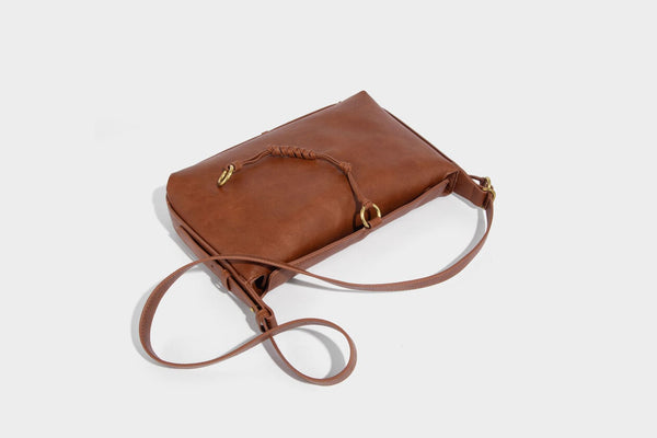Slouchy brown leather-look shoulder bag with knotted drawcord tie closure, gold-tone ring hardware, and long adjustable