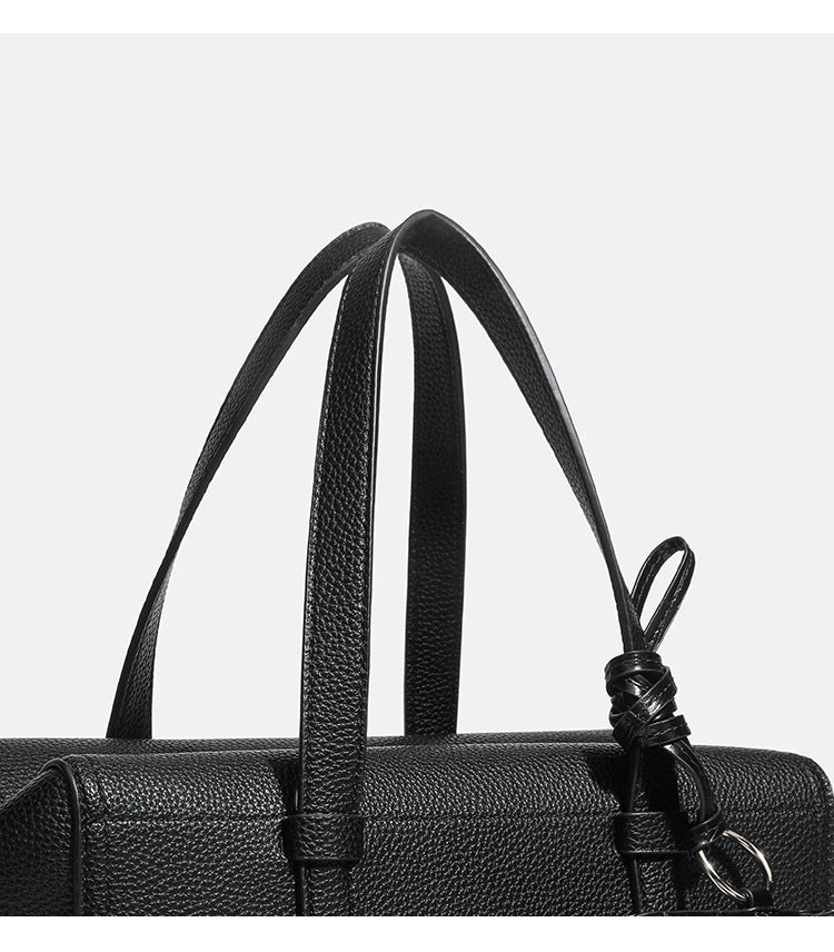 Structured pebbled leather-look top-zip barrel bag with dual handles, detachable shoulder strap, and attached croc-pattern