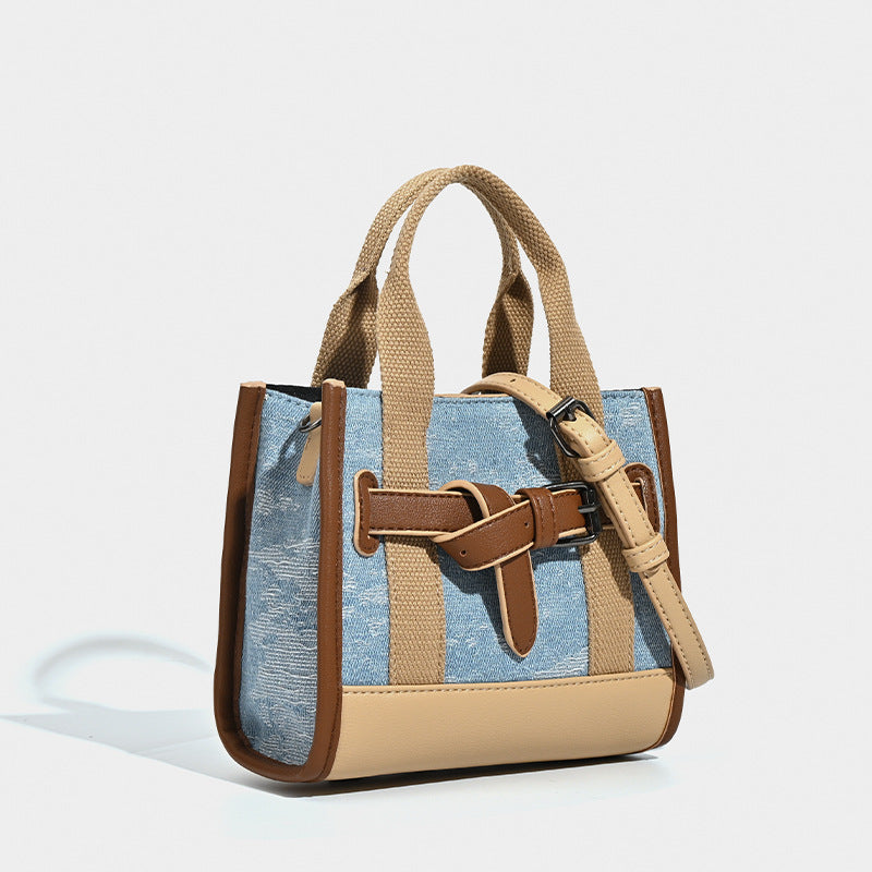 Structured mini tote bag in washed denim and neutral colorblock with brown leather-look trim and front belt buckle detail