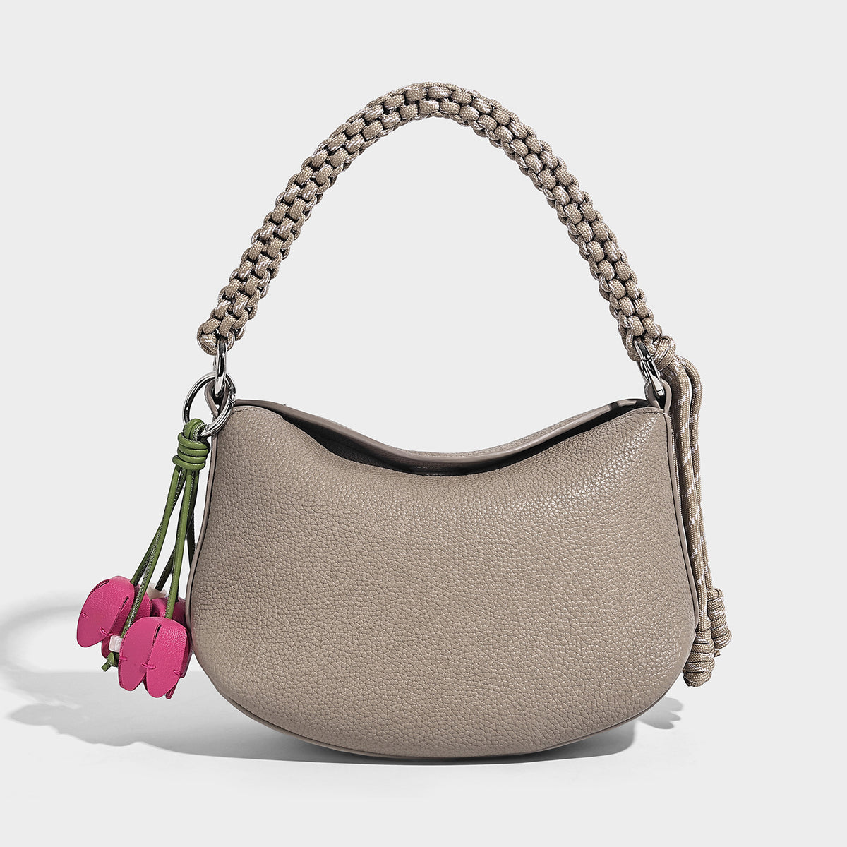 Small crescent half-moon bag in pebbled leather-look finish with braided top handle, silver-tone ring hardware, and, detail