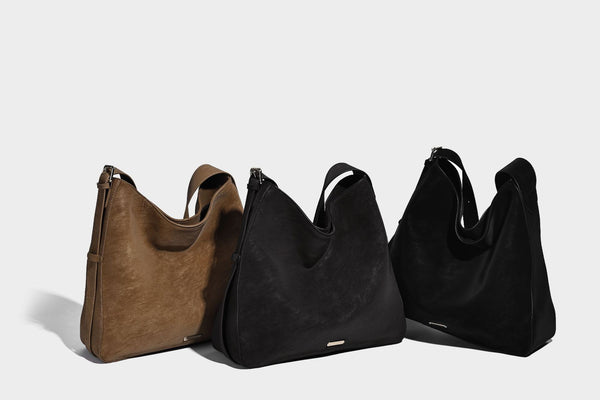 Large slouchy hobo shoulder bag in matte leather-look finish with adjustable strap and gold-tone bar hardware, detail view 11
