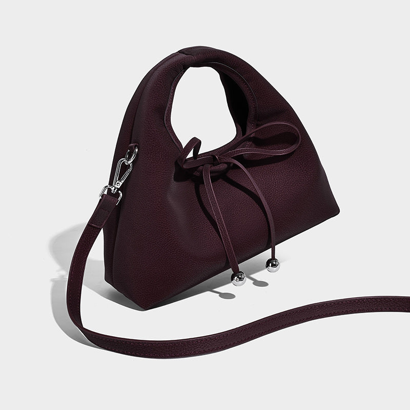 Pebbled matte trapezoid top-handle bag with drawstring bow closure, bead-tipped cords, silver-tone hardware, and detachable
