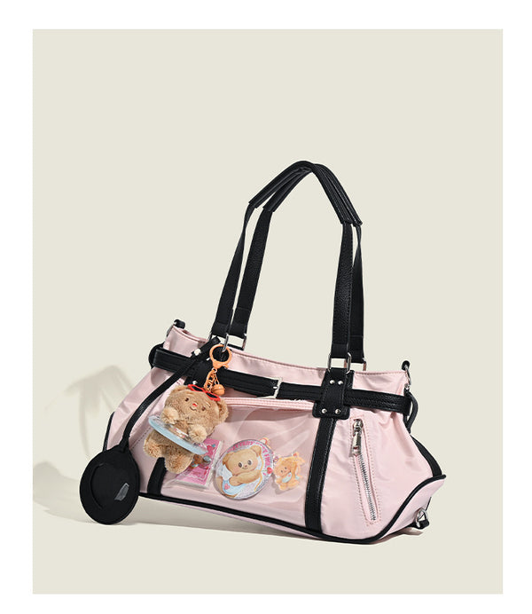 Pale pink nylon tote bag with black leather-look trim, double top handles, side zip pocket, and detachable crossbody strap