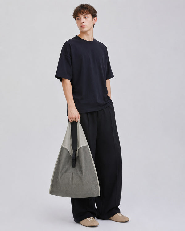 Oversized triangular mesh tote bag with matte olive-khaki fabric straps and trim, dark open-weave mesh body, matte black