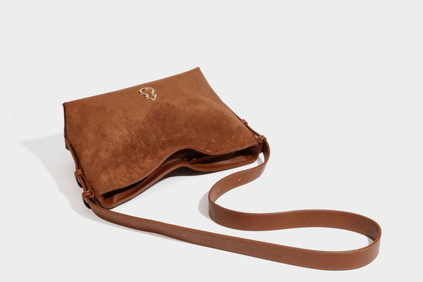 Slouchy suede-finish brown shoulder bag with long single strap and small gold-tone logo emblem on front, detail view 30