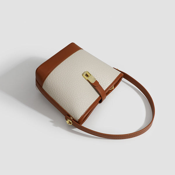 Formstabile zweifarbige Bucket Bag aus genarbtem Material mit goldfarbenem Drehverschluss und cognacfarbenem Besatz in Lederoptik, Detailansicht 4