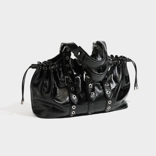 Large black glossy leather-look tote bag with silver buckle straps, eyelet grommet panels, drawstring side gathers, and
