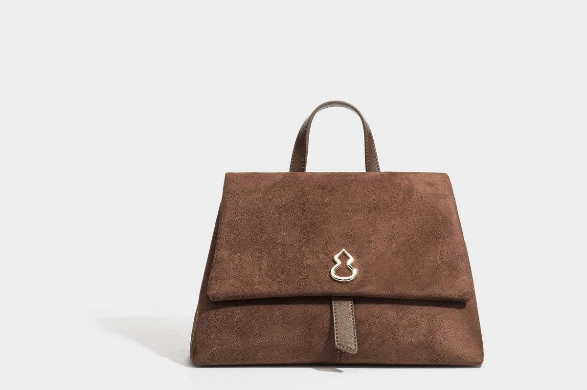 Formstabile Satchel-Tasche mit mattem Veloursleder-Finish, Überschlag, goldfarbenen Emblem-Beschlägen, kurzem Tragegriff und verstellbarem Crossbody-Riemen