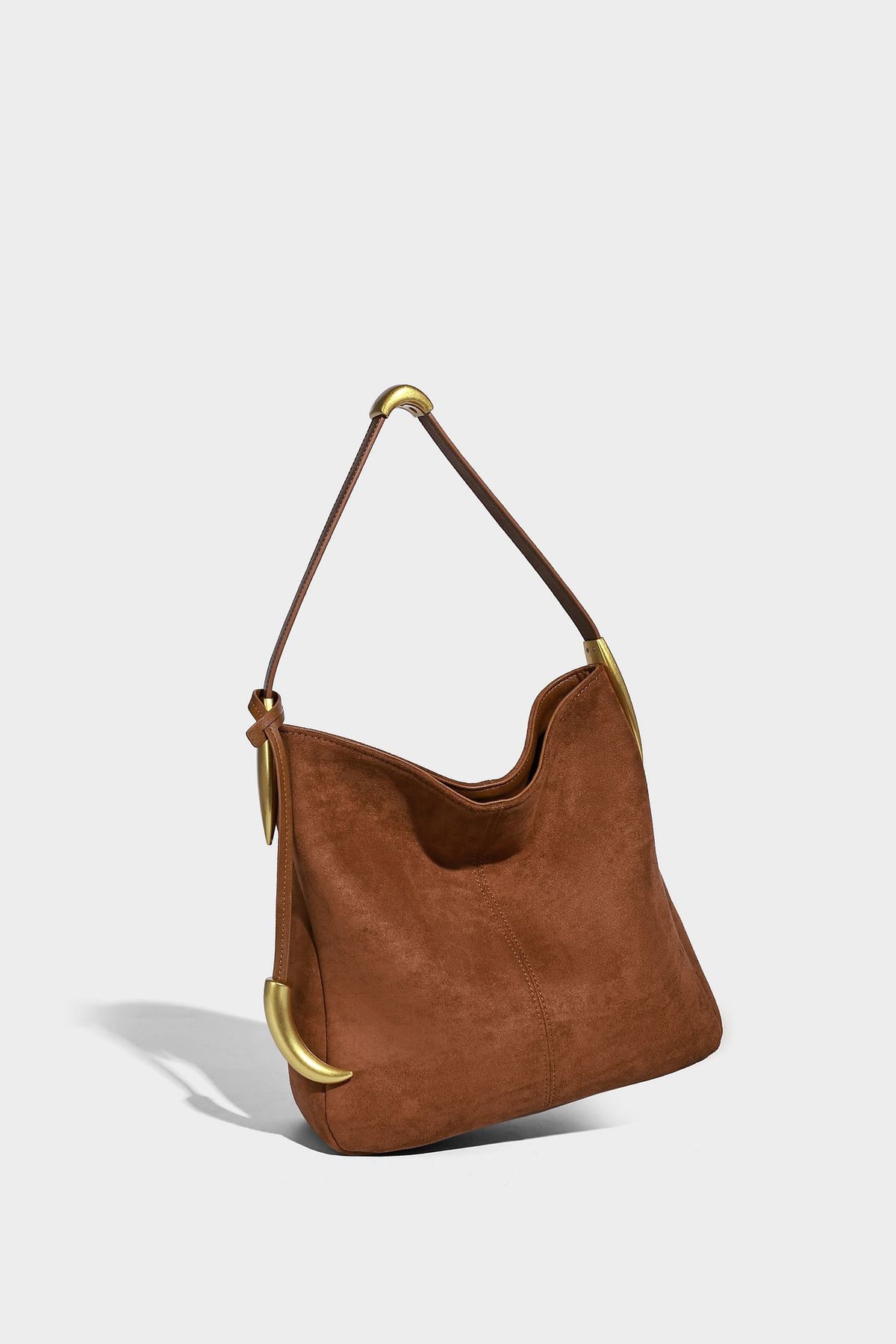 Beige-braune Hobo-Schultertasche mit lässiger Silhouette, matter Veloursleder-Optik, goldfarbenen halbmondförmigen Beschlägen und schmalem Schulterriemen, Detailaufnahme