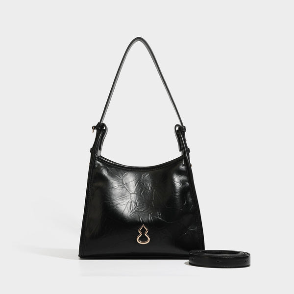 Strukturierte Trapez-Schultertasche mit glänzender, geknitterter Oberfläche in Lederoptik, goldfarbenen Beschlägen an der Vorderseite und langem, verstellbarem