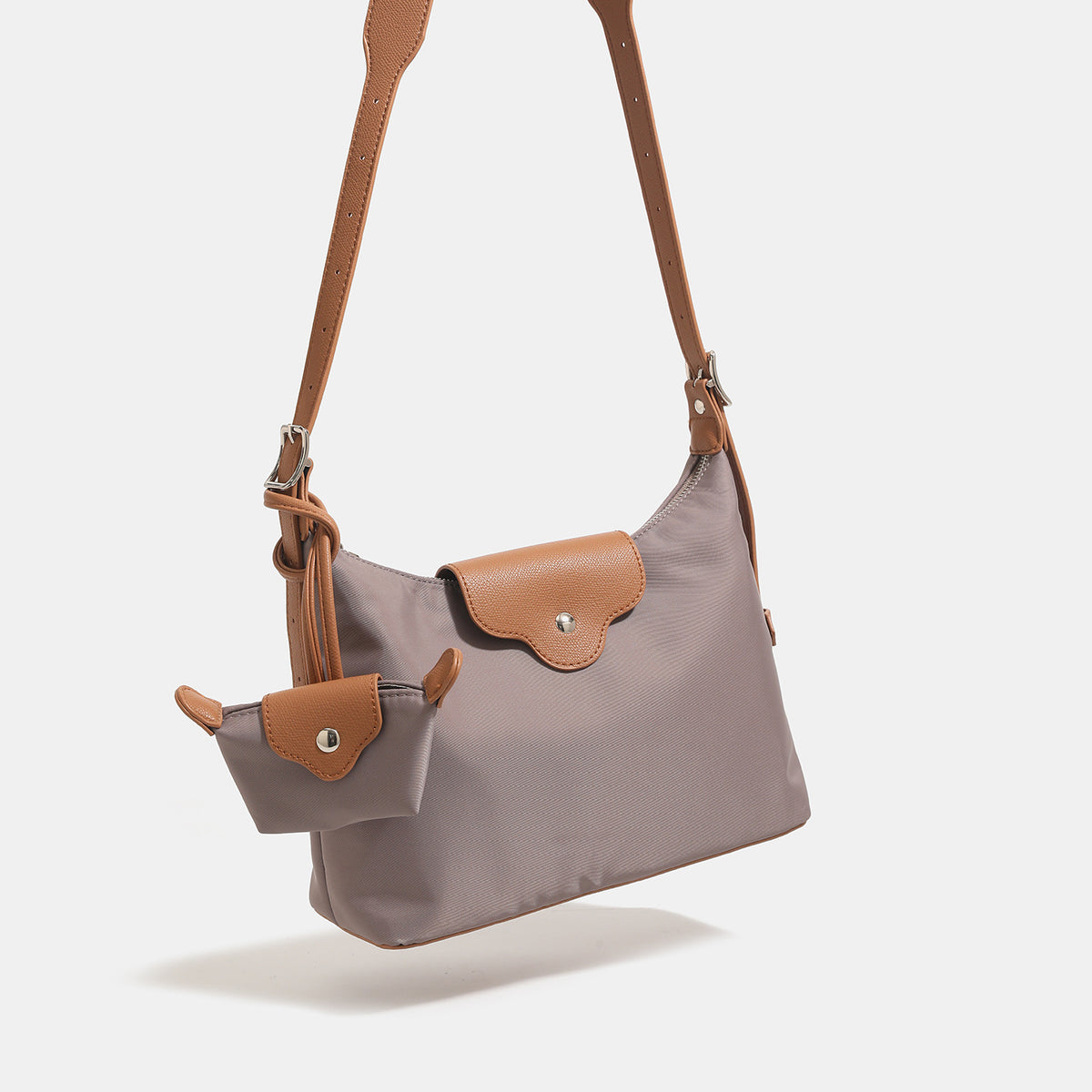 Slouchy hobo shoulder bag in smooth fabric with leather-look tan trim, zip-top closure, adjustable strap, and detachable