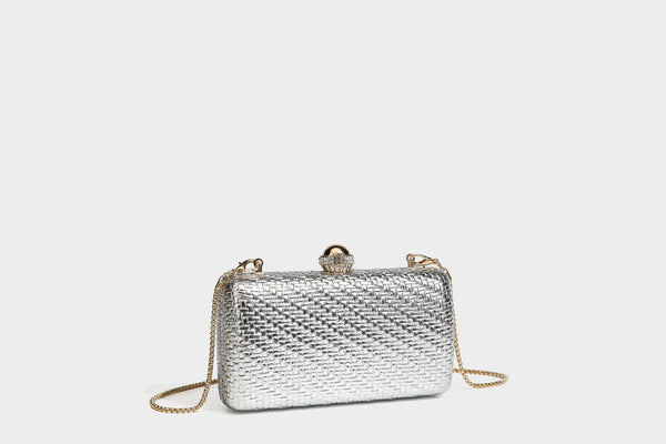 Small structured metallic woven-texture box clutch bag with jeweled kiss-lock dome clasp and slim gold chain strap, detail