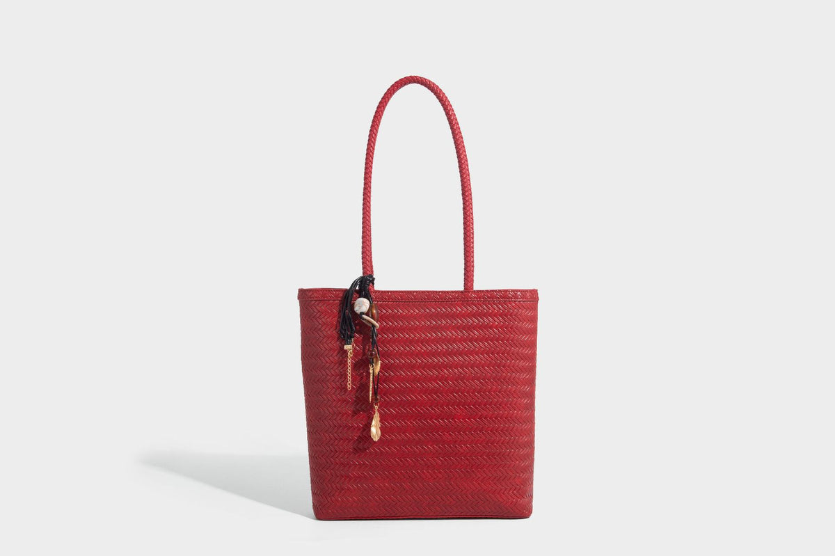 Structured woven herringbone tote bag with braided double shoulder handles in tan brown, shown with matching drawstring